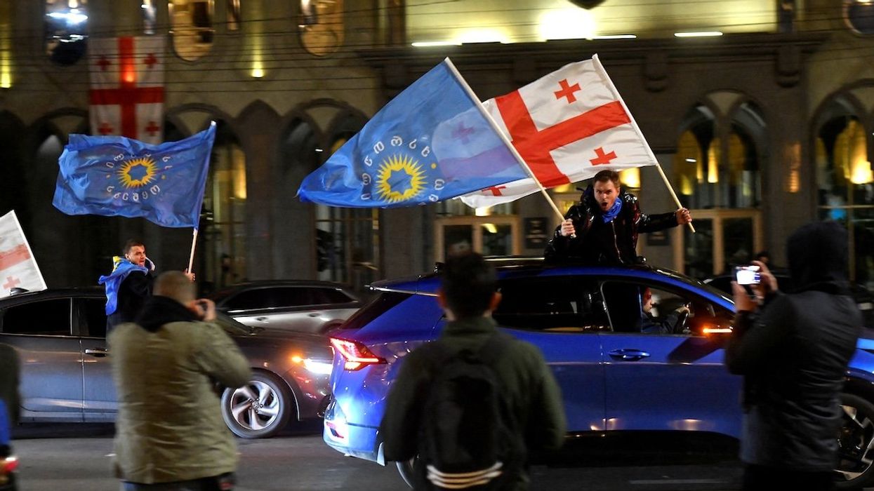 Supporters of the Georgian Dream party wave Georgian and party flags from cars after the announcement of poll results in parliamentary elections, in Tbilisi, Georgia, on Oct. 26, 2024.