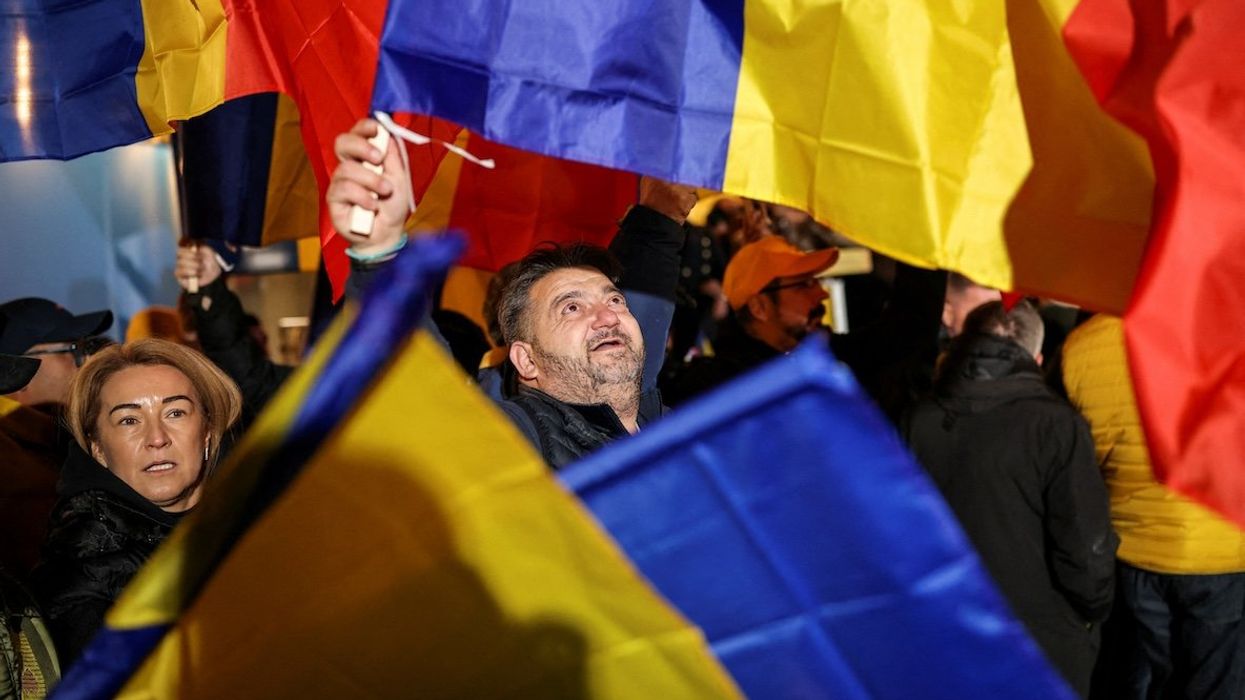 Supporters of the radical right Alliance for Uniting Romanians wave Romanian flags following the first exit polls, at the party’s campaign headquarters, on the day of the parliamentary election, in Bucharest, Romania, on Dec. 1, 2024.
