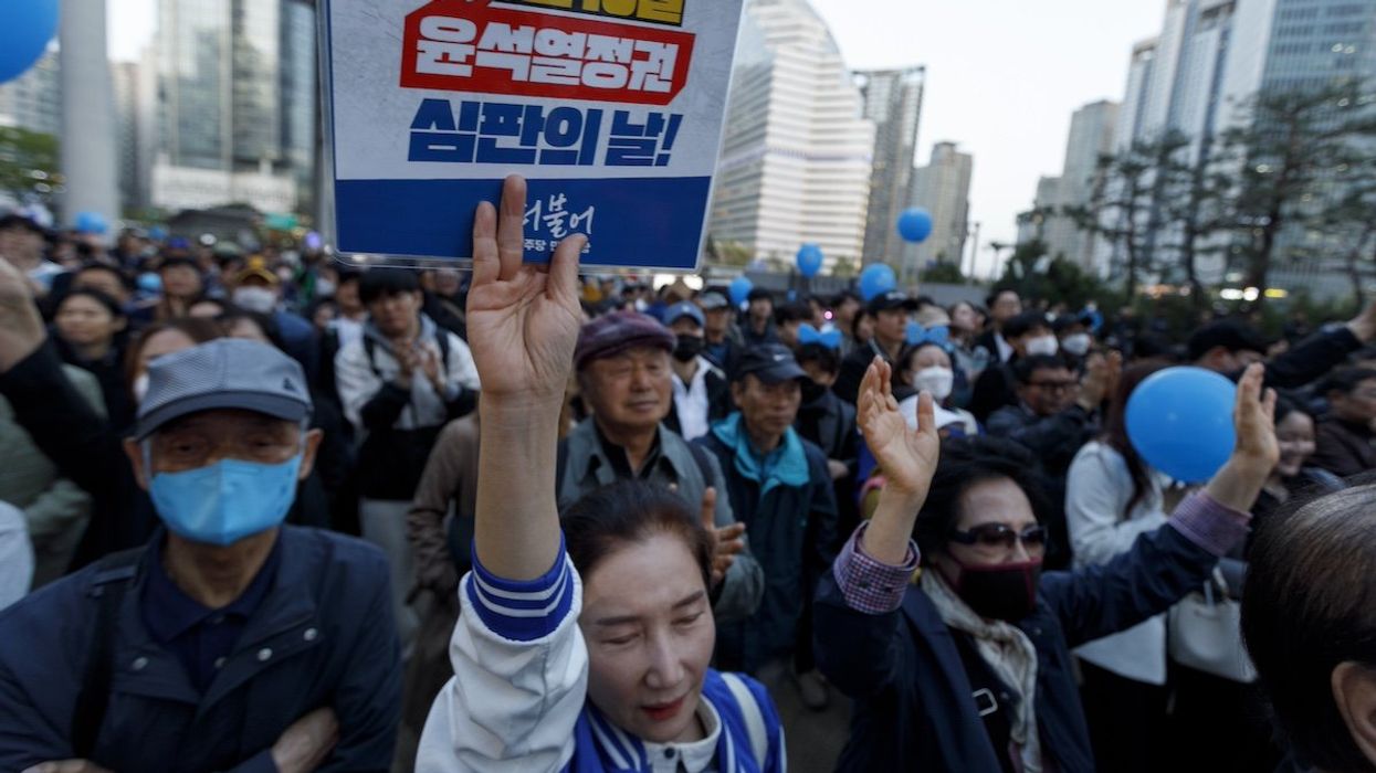 Supporters with a placard 'April 10 is the Yoon Suk Yeol government, Judgment Day.' attend the Democratic Party of Korea's general election campaign rally at Yongsan Station Square in Seoul, South Korea, April 9, 2024.