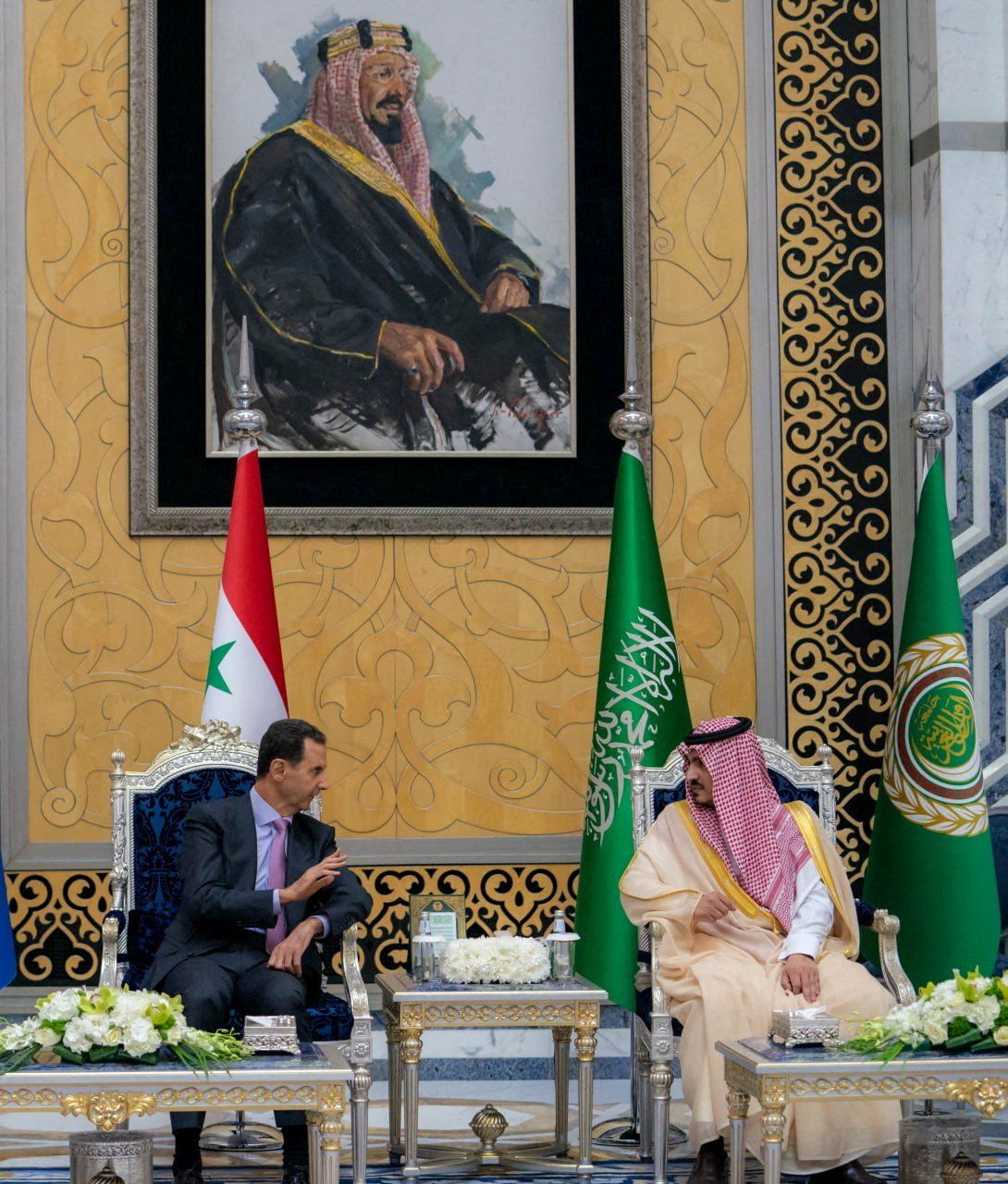 Syria's President Bashar al-Assad chats with Prince Badr bin Sultan bin Abdulaziz