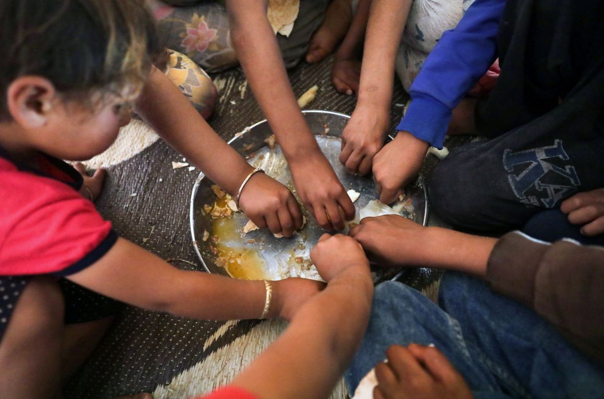 Syrian children eat inside their tent in a refugee camp near the Turkish border. Reuters