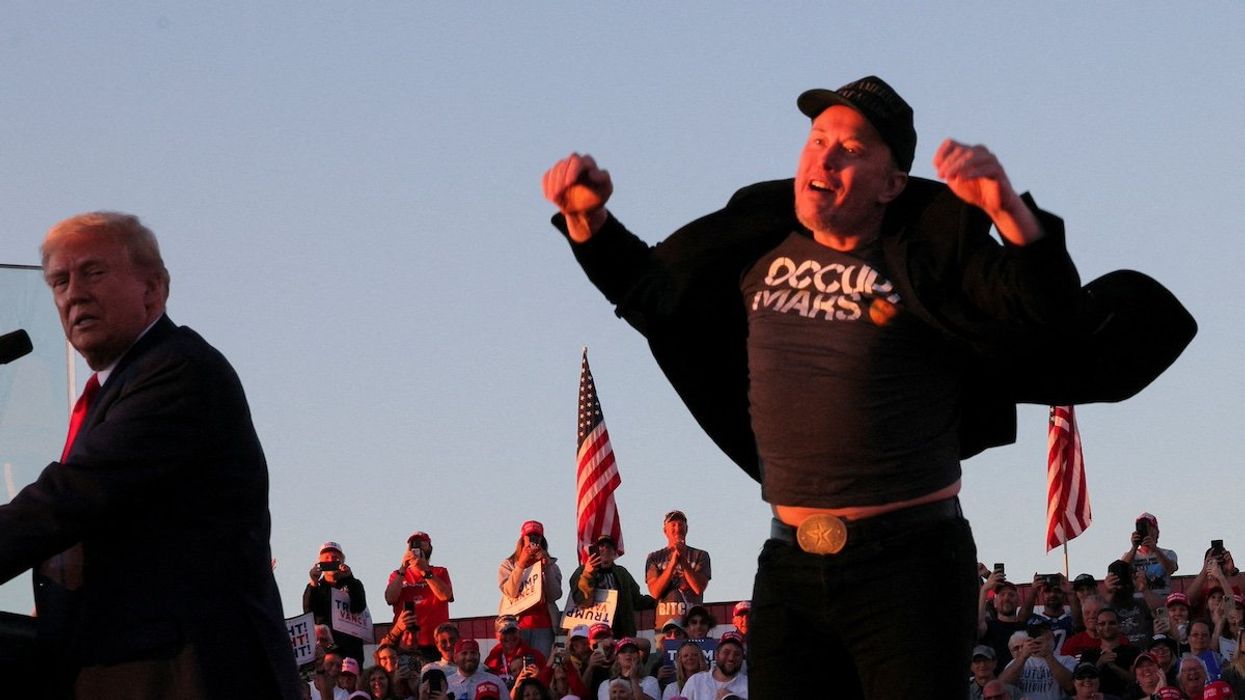 Tesla CEO and X owner Elon Musk reacts next to Republican presidential nominee and former U.S. president Donald Trump during a campaign rally, at the site of the July assassination attempt against Trump, in Butler, Pennsylvania, U.S., October 5, 2024.