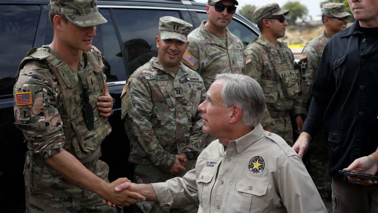 Texas Governor Gregg Abbott shakes hands with a U.S. Soldier after a news conference near the International Bridge between Mexico and the U.S., where migrants seeking asylum in the U.S. are waiting to be processed, in Del Rio, Texas, U.S., September 21, 2021.
