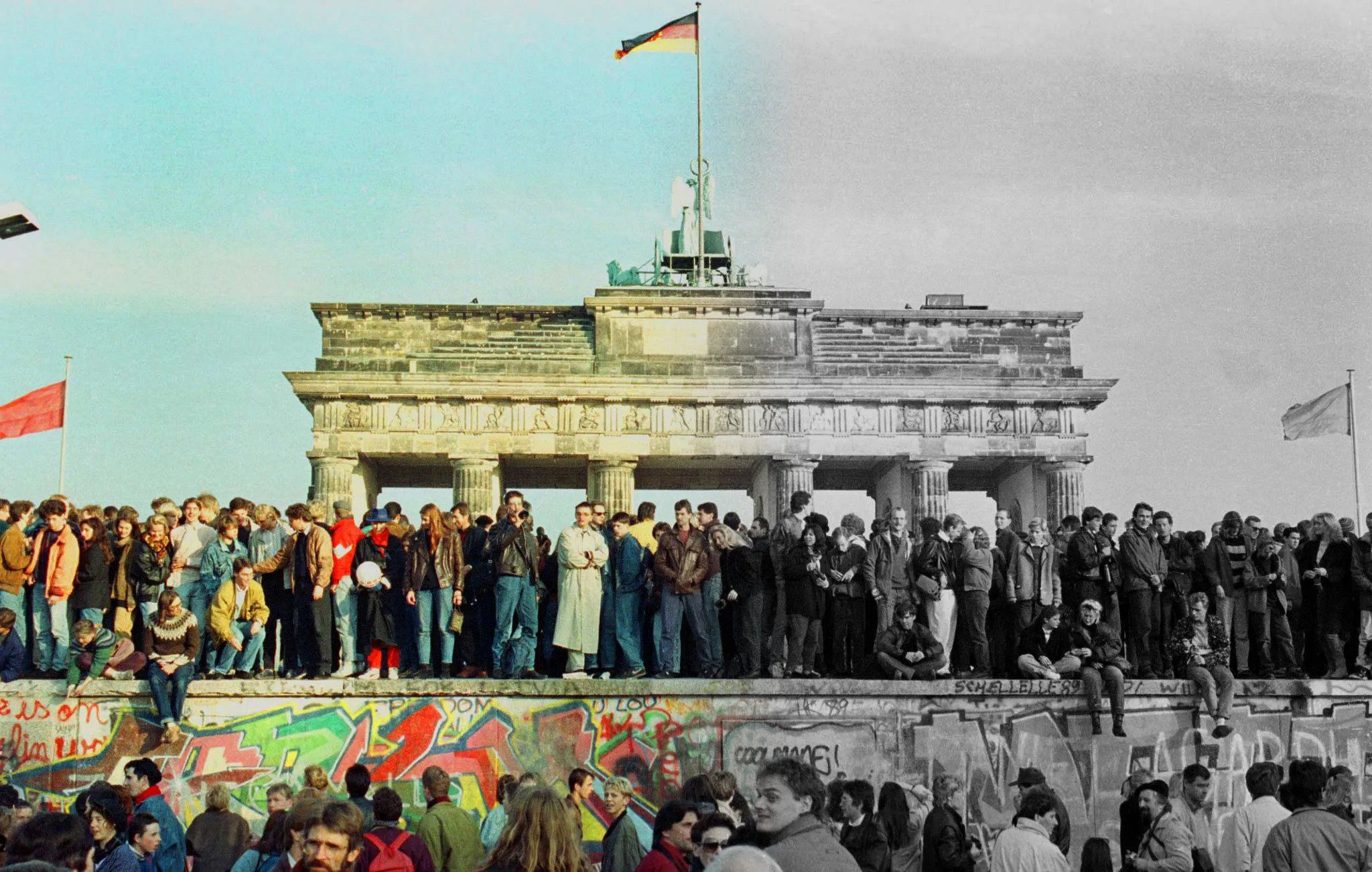 The Brandenburg Gate with a German flag during the period of reunification in Berlin, Germany