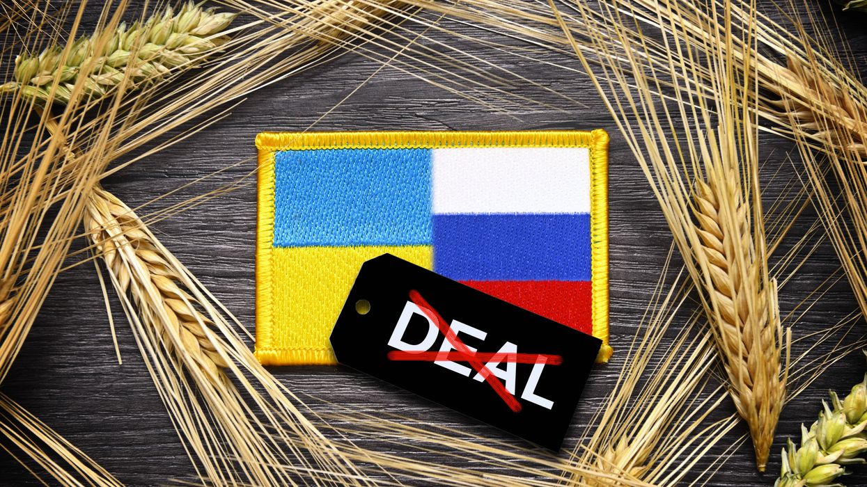The flags of Ukraine and Russia surrounded by ears of grain and label with crossed-out inscription "Deal."