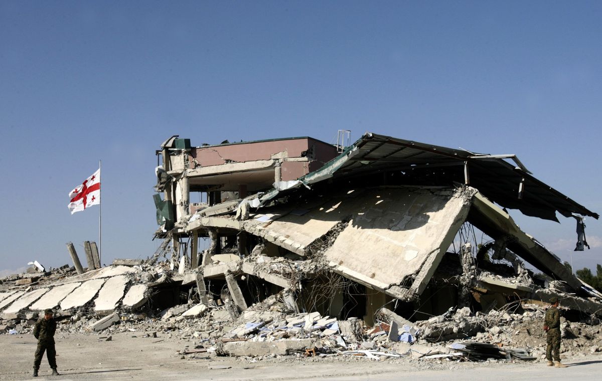 ​The Georgian flag flies next to a destroyed building at a military base in Gori, Georgia, on Sept. 16, 2008. 