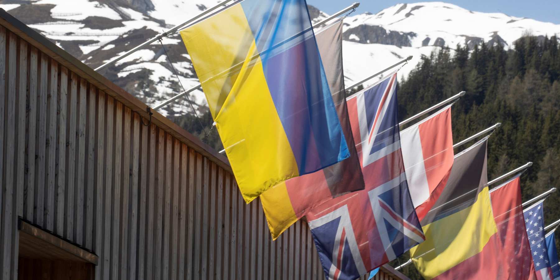 The national flag of Ukraine flies along with other countries' flags at the congress center for the 2022 edition of the World Economic Forum.