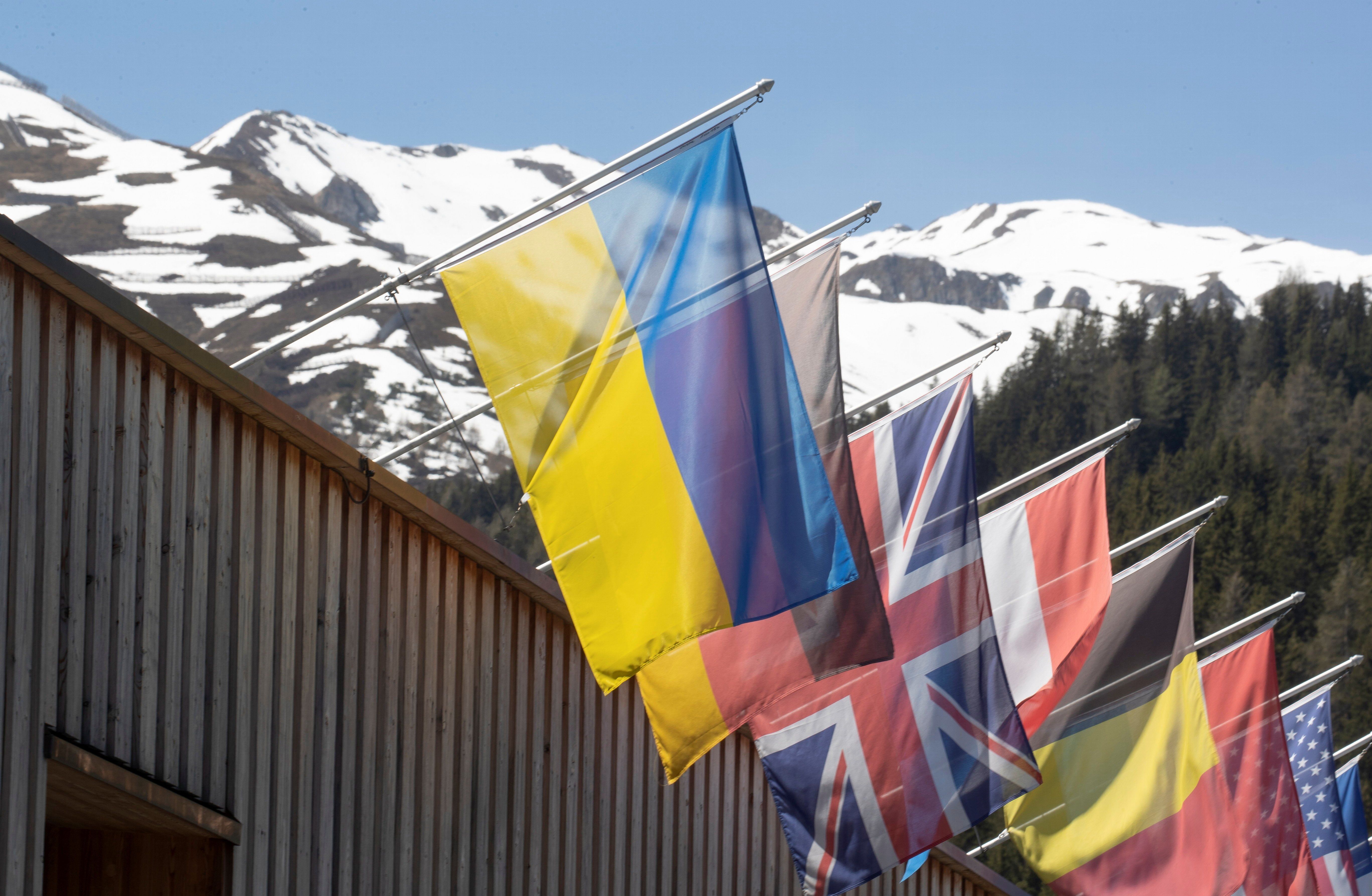 The national flag of Ukraine flies along with other countries' flags at the congress center for the 2022 edition of the World Economic Forum. 