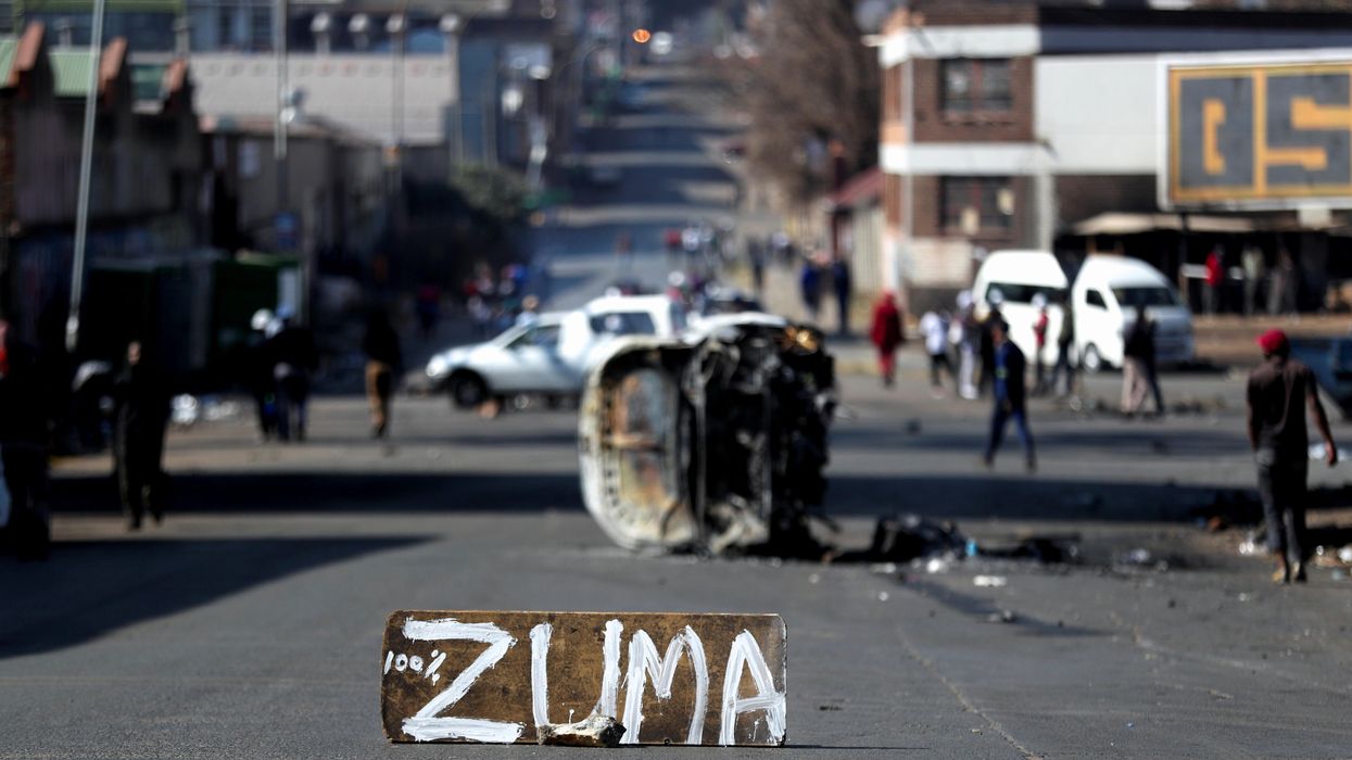 The remains of a burnt car and a sign block the road after stick-wielding protesters marched through the streets, as violence following the jailing of former South African President Jacob Zuma spread to the country's main economic hub in Johannesburg, South Africa, July 11, 2021