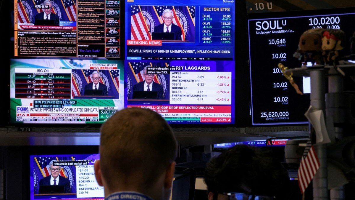 ​Traders work on the New York Stock Exchange floor as screens broadcast a news conference by US Federal Reserve Chair Jerome Powell following the Fed rate announcement on May 7, 2025.