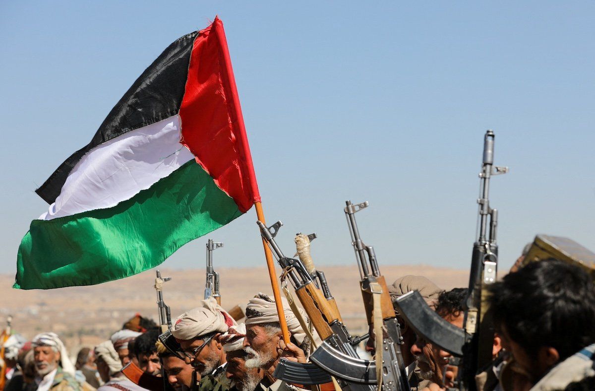 Tribal supporters of Yemen's Houthis wave a Palestinian flag and hold up their firearms during a protest on recent U.S.-led strikes on Houthi targets, near Sanaa, Yemen January 14, 2024.