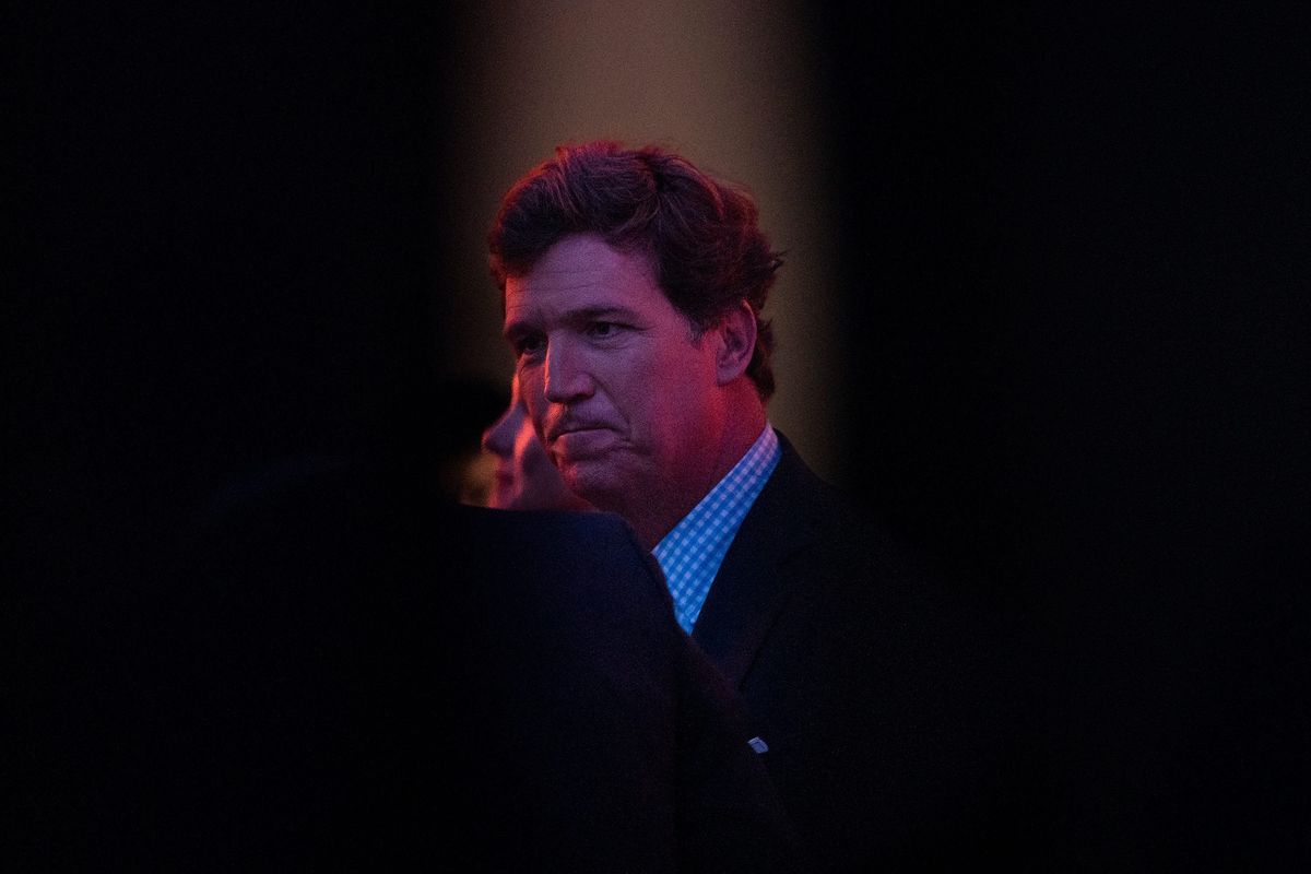 Tucker Carlson chats with people backstage before speaking during the FAMiLY Leadership Summit in Des Moines, Iowa.