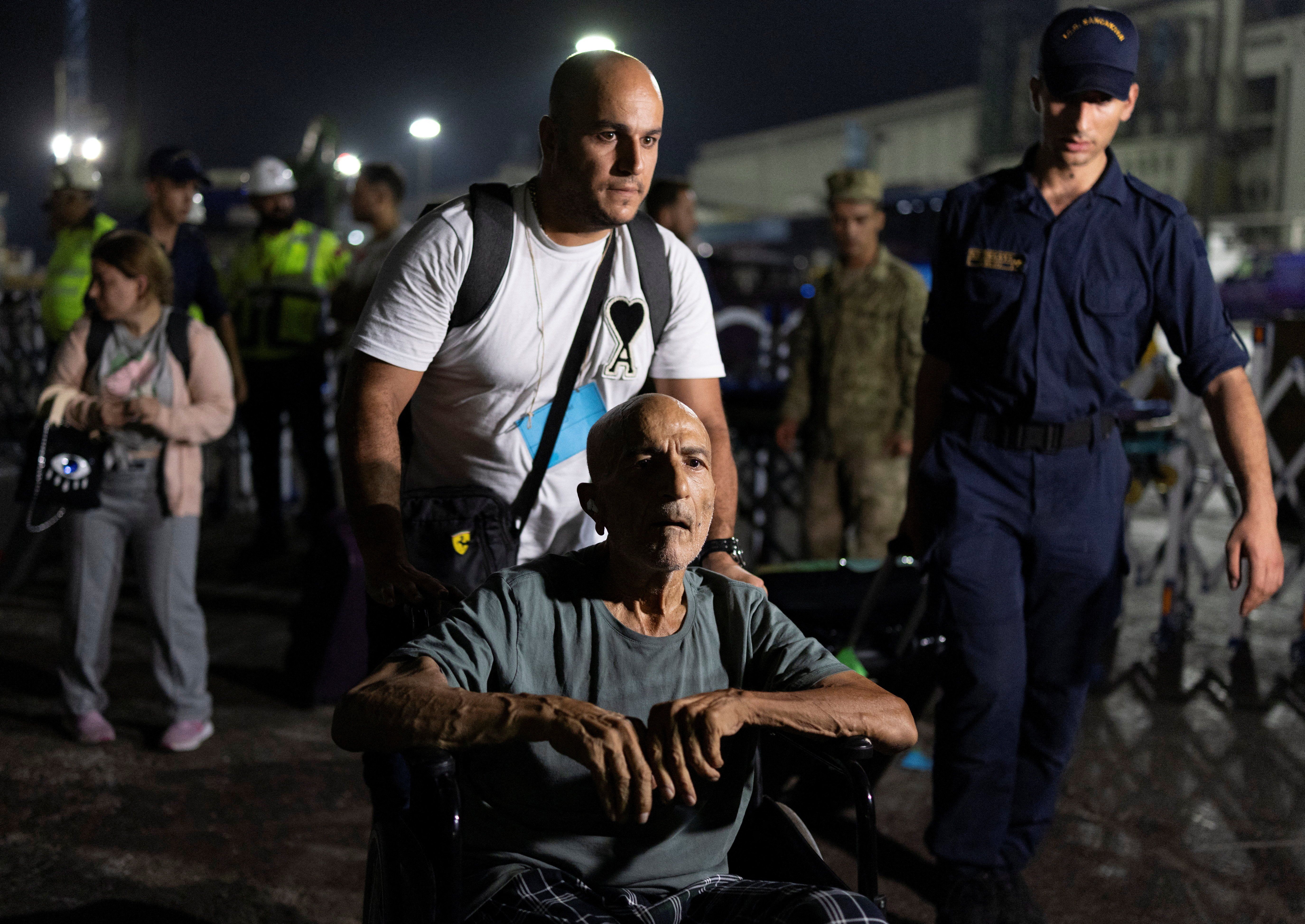 Turkish citizens disembark naval ship TCG Bayraktar carrying people evacuated from Lebanon upon their arrival at a port in Turkey's Mediterranean coastal province of Mersin, Turkey, October 10, 2024.