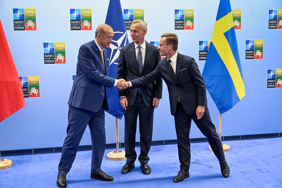 Turkish President Recep Tayyip Erdogan and Swedish Prime Minister Ulf Kristersson shake hands next to NATO Secretary-General Jens Stoltenberg in Vilnius, Lithuania.