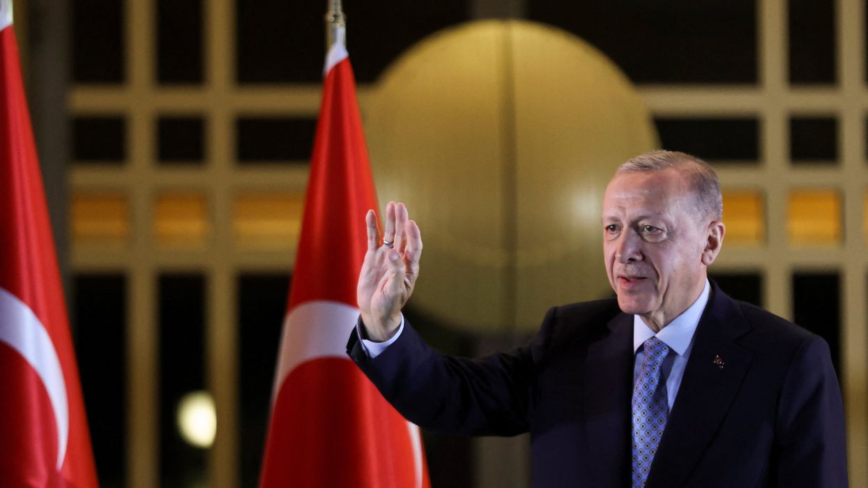 Turkish President Tayyip Erdogan waves as he addresses his supporters in Ankara following his victory in the second round of the presidential election.