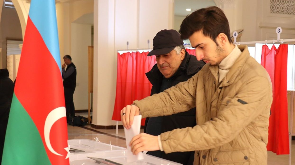 Two men cast their votes in the early presidential election in the Azerbaijani capital on Wednesday.