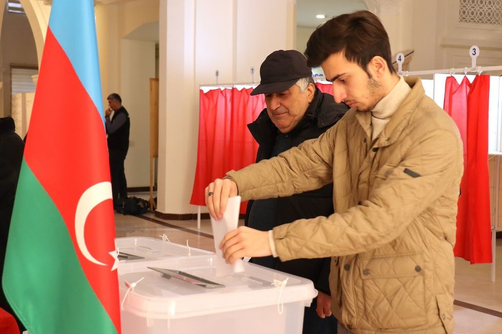 Two men cast their votes in the early presidential election in the Azerbaijani capital on Wednesday.​