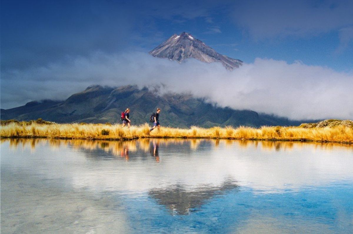 Two people hiking with a mountain backdrop