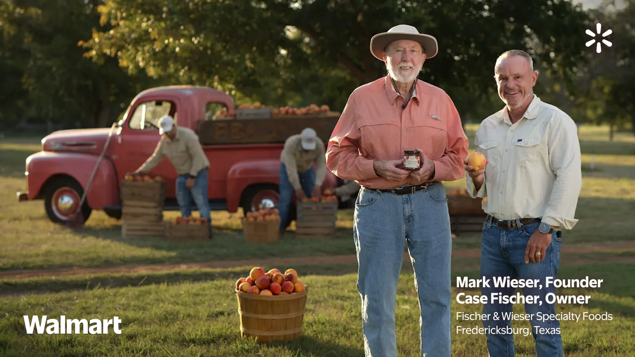 Two people picking peaches on a peach farm with a car in the background