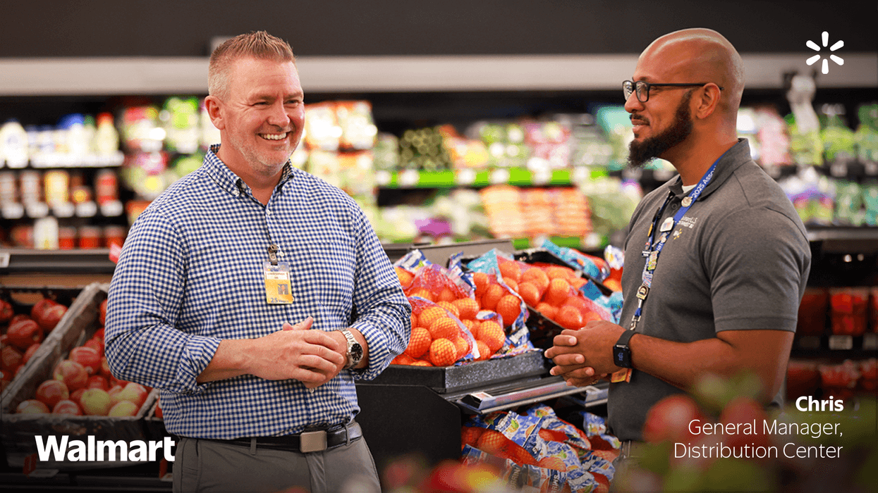 Two Walmart employees looking at each other and talking at a store