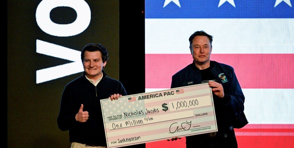 U.S. President Donald Trump's adviser Elon Musk gives a check to an audience member during a rally in support of a conservative state Supreme Court candidate of an April 1 election in Green Bay, Wisconsin, U.S. March 30, 2025. 