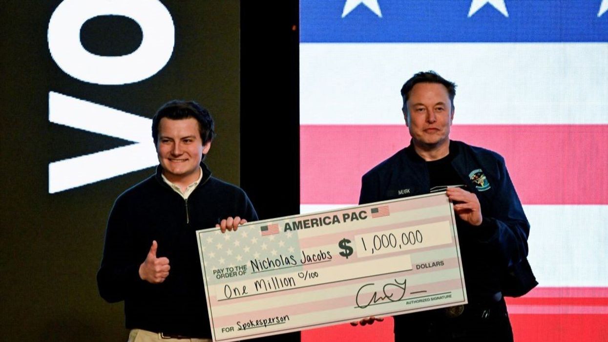 U.S. President Donald Trump's adviser Elon Musk gives a check to an audience member during a rally in support of a conservative state Supreme Court candidate of an April 1 election in Green Bay, Wisconsin, U.S. March 30, 2025.