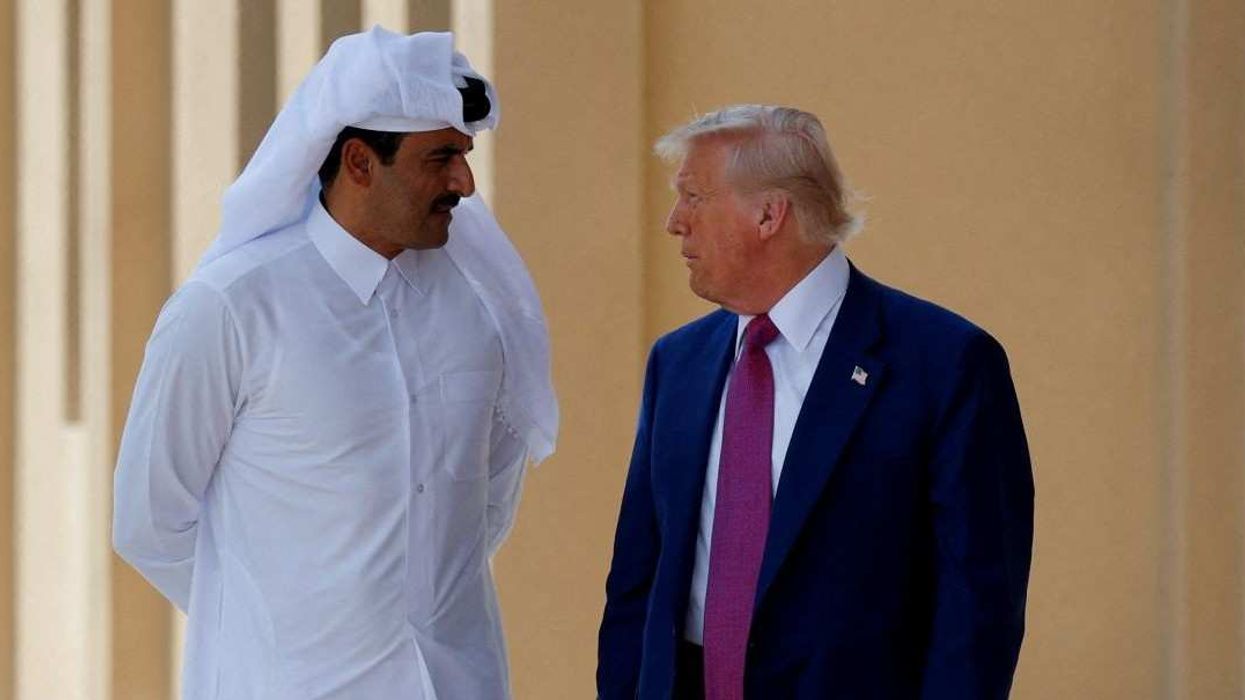 U.S. President Donald Trump talks with Qatar's Emir Tamim bin Hamad Al Thani in Doha, Qatar, May 15, 2025.