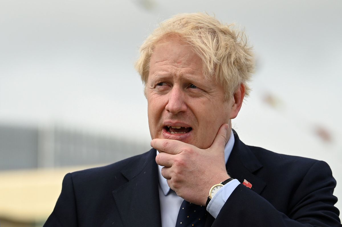 UK Prime Minister Boris Johnson with a hand to his chin looking concerned 