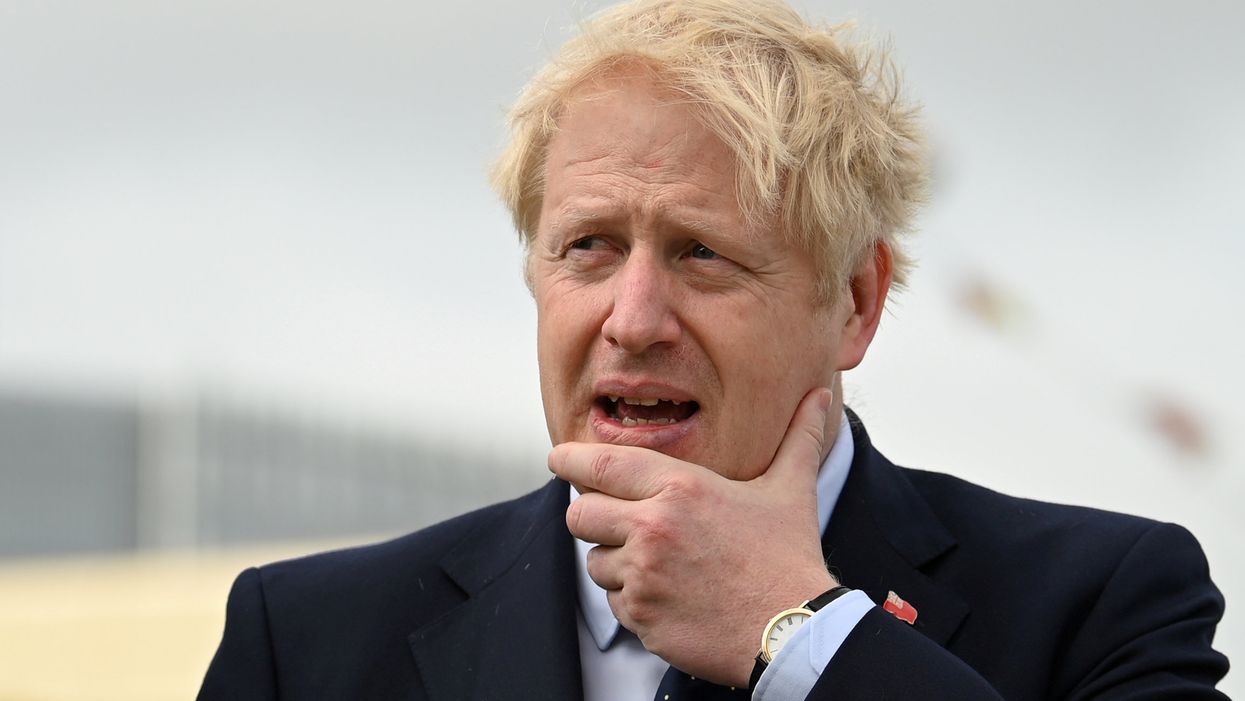 UK Prime Minister Boris Johnson with a hand to his chin looking concerned