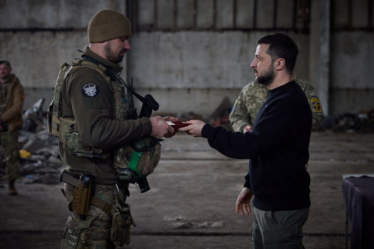 ​Ukraine's President Volodymyr Zelenskiy awards a Ukrainian service member at a position near a frontline, in Donetsk region, Ukraine March 22, 2023.