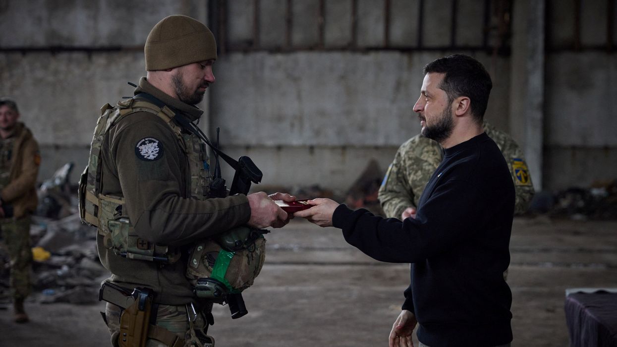 Ukraine's President Volodymyr Zelenskiy awards a Ukrainian service member at a position near a frontline, in Donetsk region, Ukraine March 22, 2023.