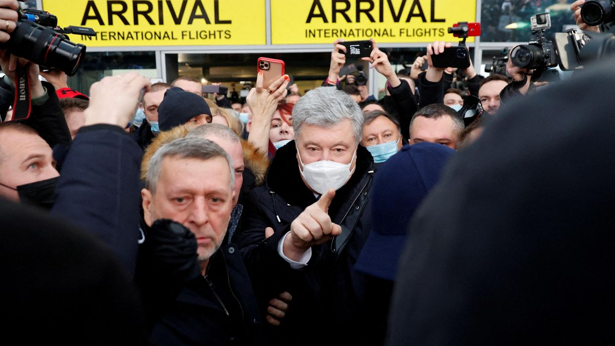 Ukrainian former President Petro Poroshenko gestures as he walks to address supporters upon arrival at Zhulyany airport in Kyiv, Ukraine January 17, 2022.