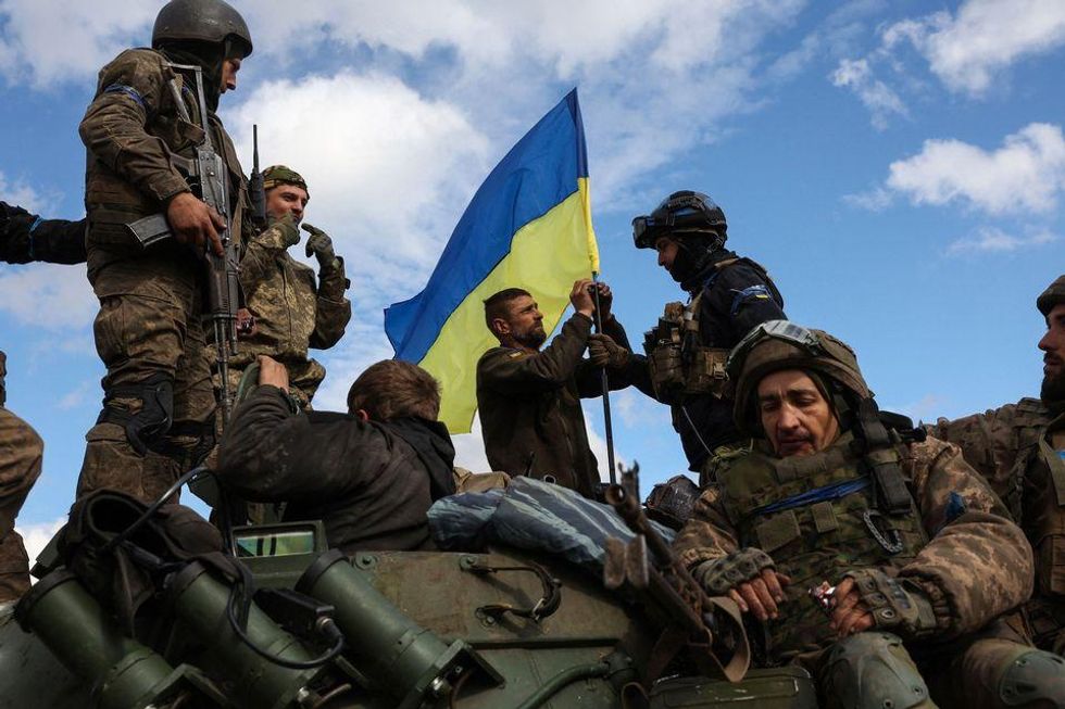 Ukrainian soldiers raise the national flag near Lyman, Donetsk region on October 4.