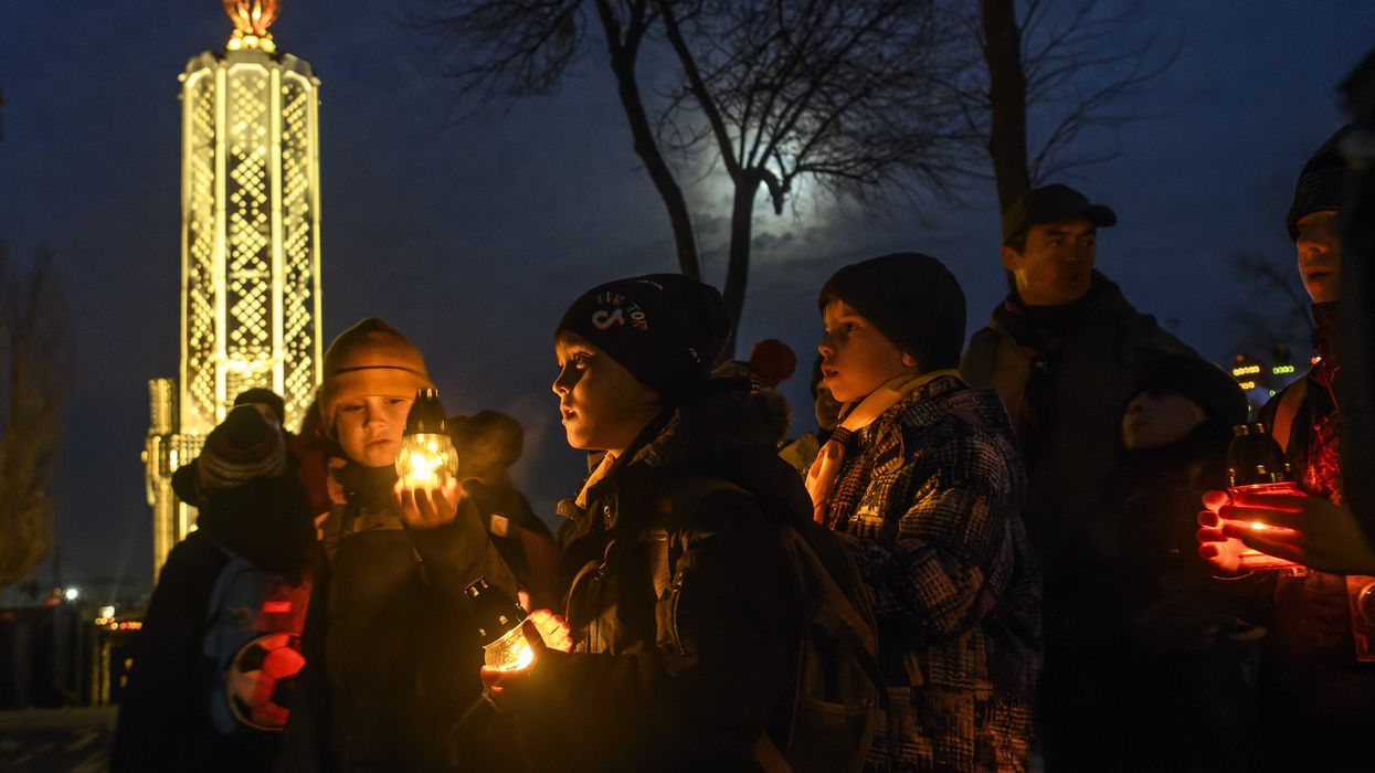 Ukrainians visit a monument to Holodomor victims during a commemoration ceremony marking the 90th anniversary of the famine of 1932-33, against a backdrop of Russian drones attacking Kyiv.