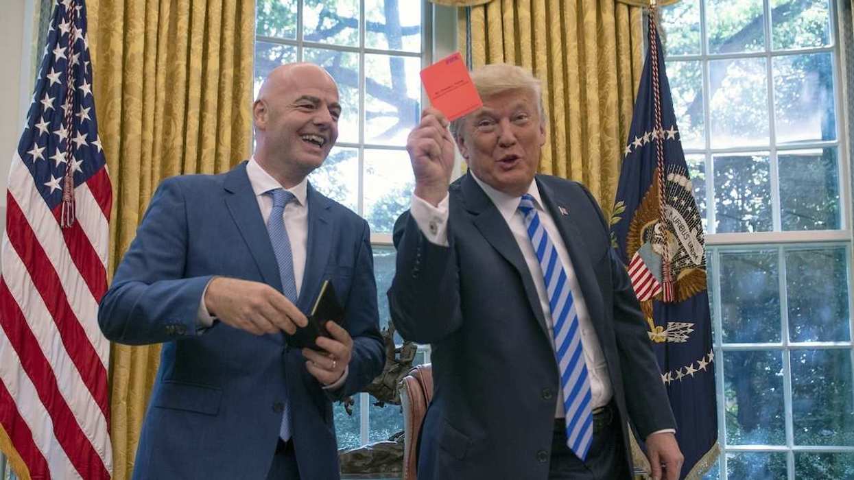 US President Donald Trump holds a red penalty card that was presented to him by FIFA President Gianni Infantino in the Oval Office of the White House, in Washington, D.C., USA, on August 28, 2018.
