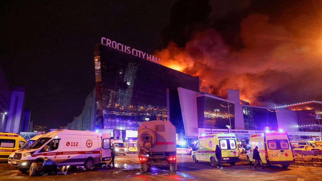Vehicles of Russian emergency services are parked near the burning Crocus City Hall concert venue following a reported shooting incident, outside Moscow, Russia, March 22, 2024.