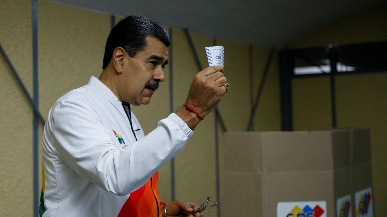 Venezuela's President Nicolas Maduro shows his ballot during a referendum over Venezuela's rights to the potentially oil-rich region of Esequiba in Guyana, in Caracas, Venezuela, on Dec. 3, 2023.