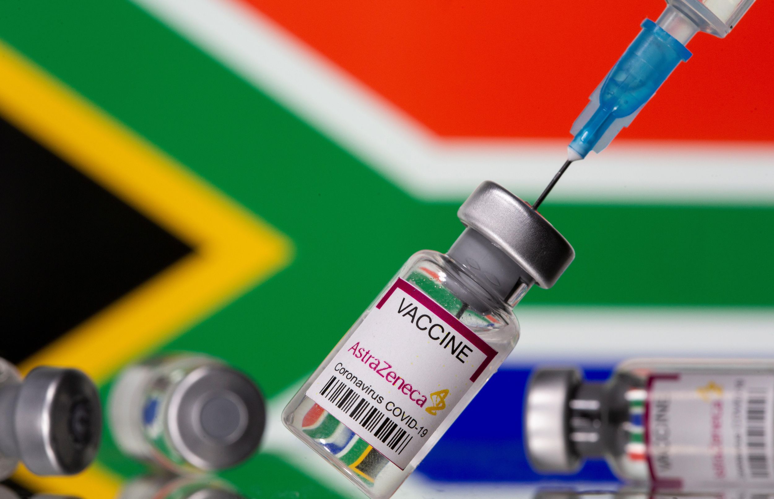 Vials labelled "Astra Zeneca COVID-19 Coronavirus Vaccine" and a syringe are seen in front of a displayed South Africa flag, in this illustration photo taken March 14, 2021.