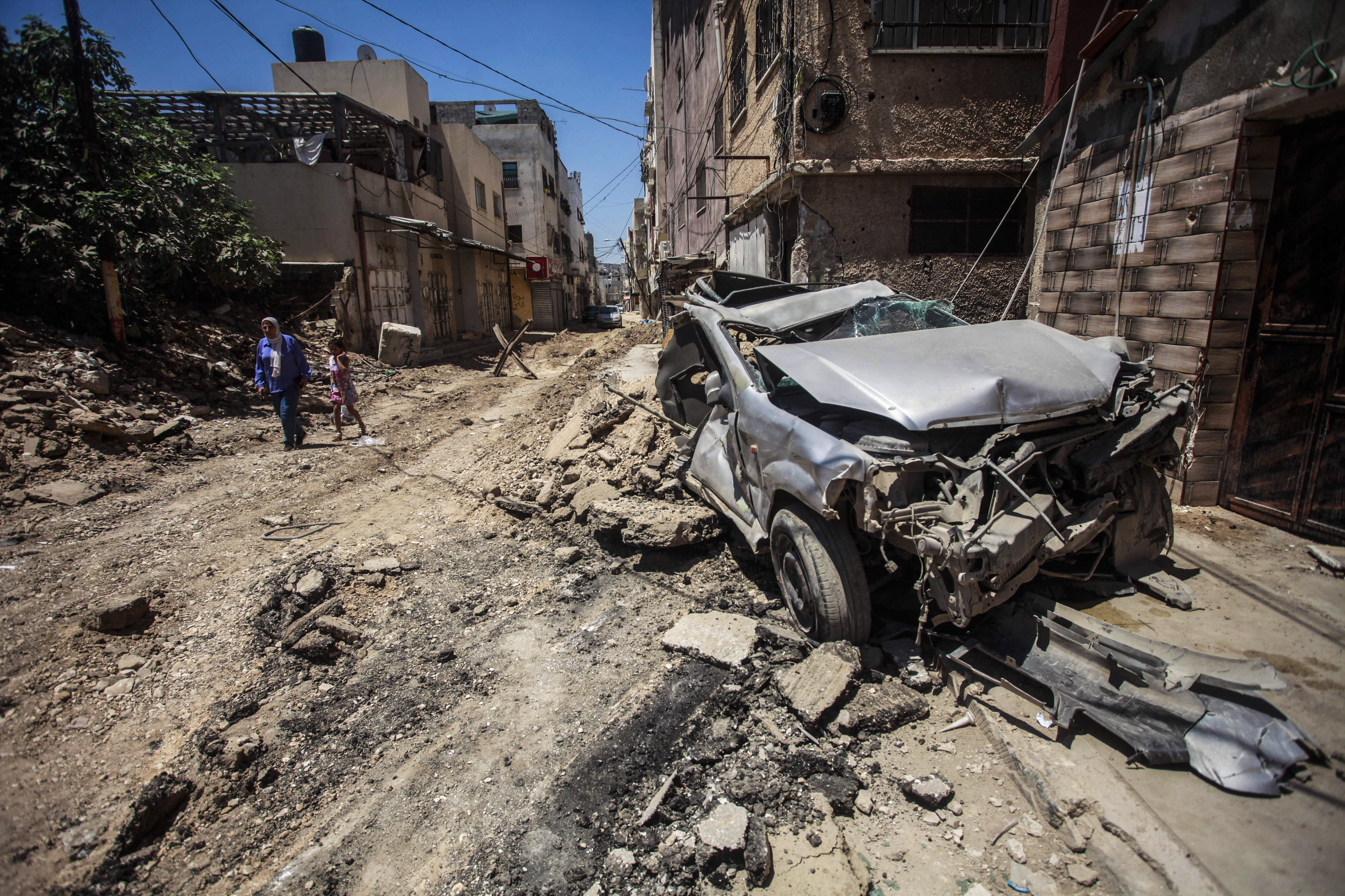 View of a destroyed car on the street caused by an Israeli airstrike on the city of Jenin in the northern occupied West Bank.