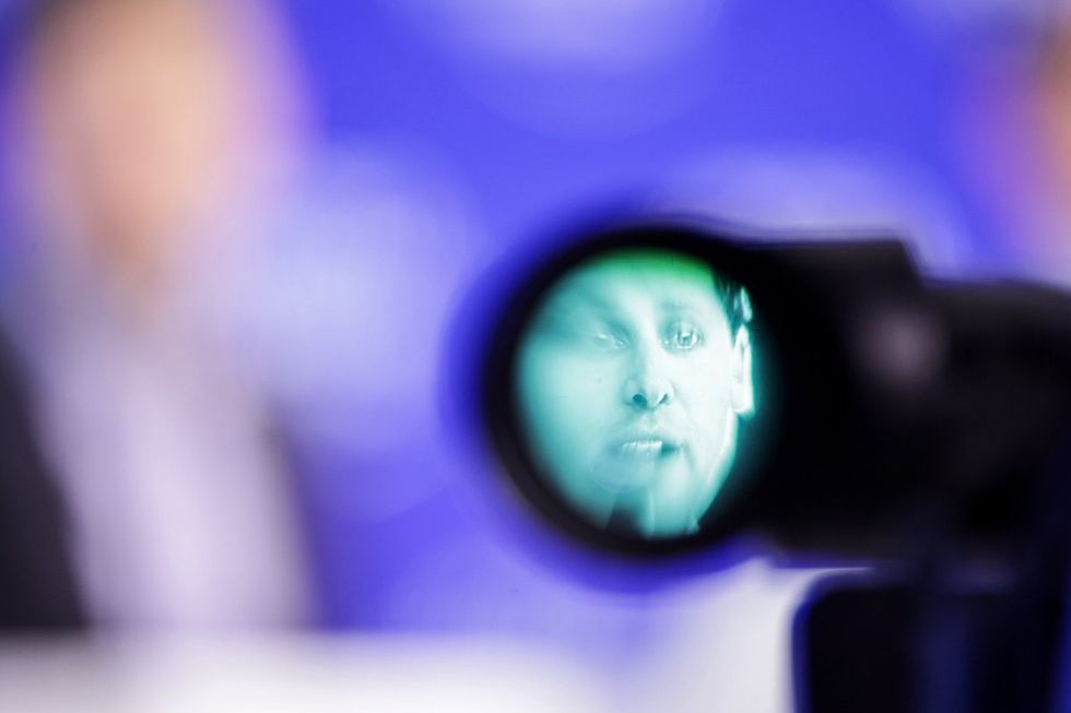 ​View through a camera viewfinder while Sam Altman, CEO of OpenAI, speaks at a World Economic Forum event in Davos.