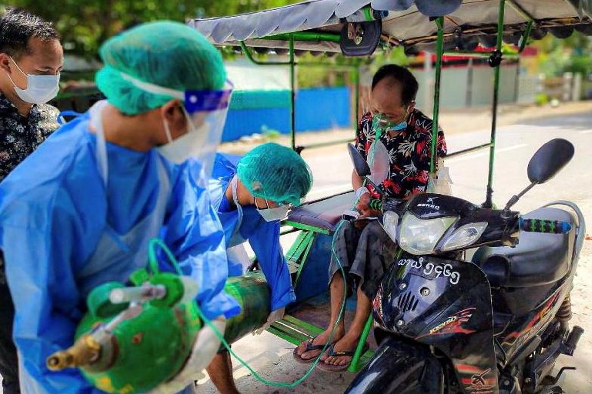 Volunteers help provide a coronavirus (COVID-19) patient with extra oxygen in the town of Kale, Sagaing Region, Myanmar, July 5, 2021. Picture taken July 5, 2021.