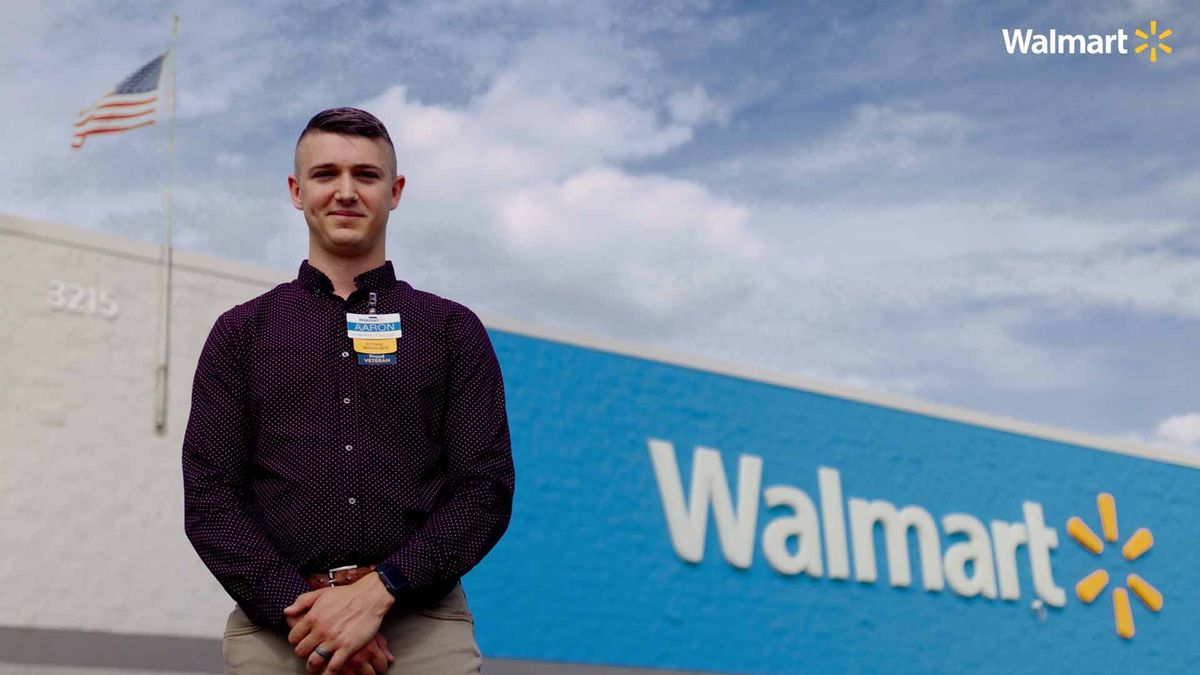 Walmart employee standing in front of the store