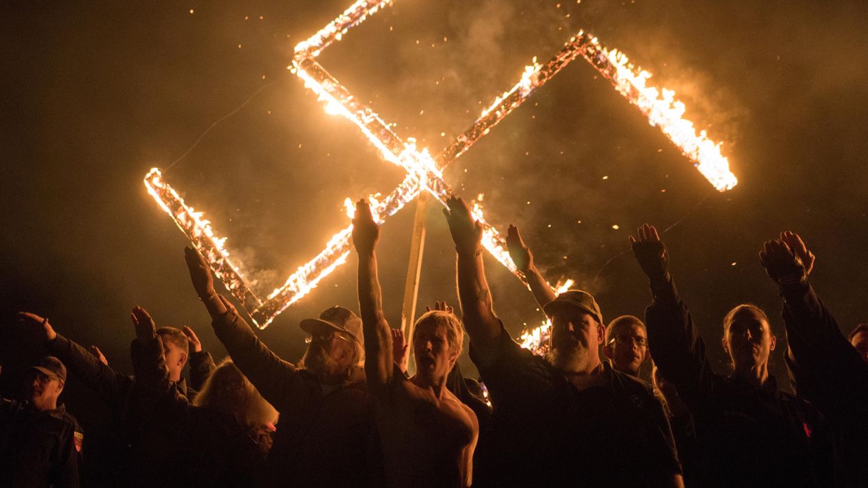 White nationalists give Nazi salutes while taking part in a swastika burning at an undisclosed location in the US state of Georgia.