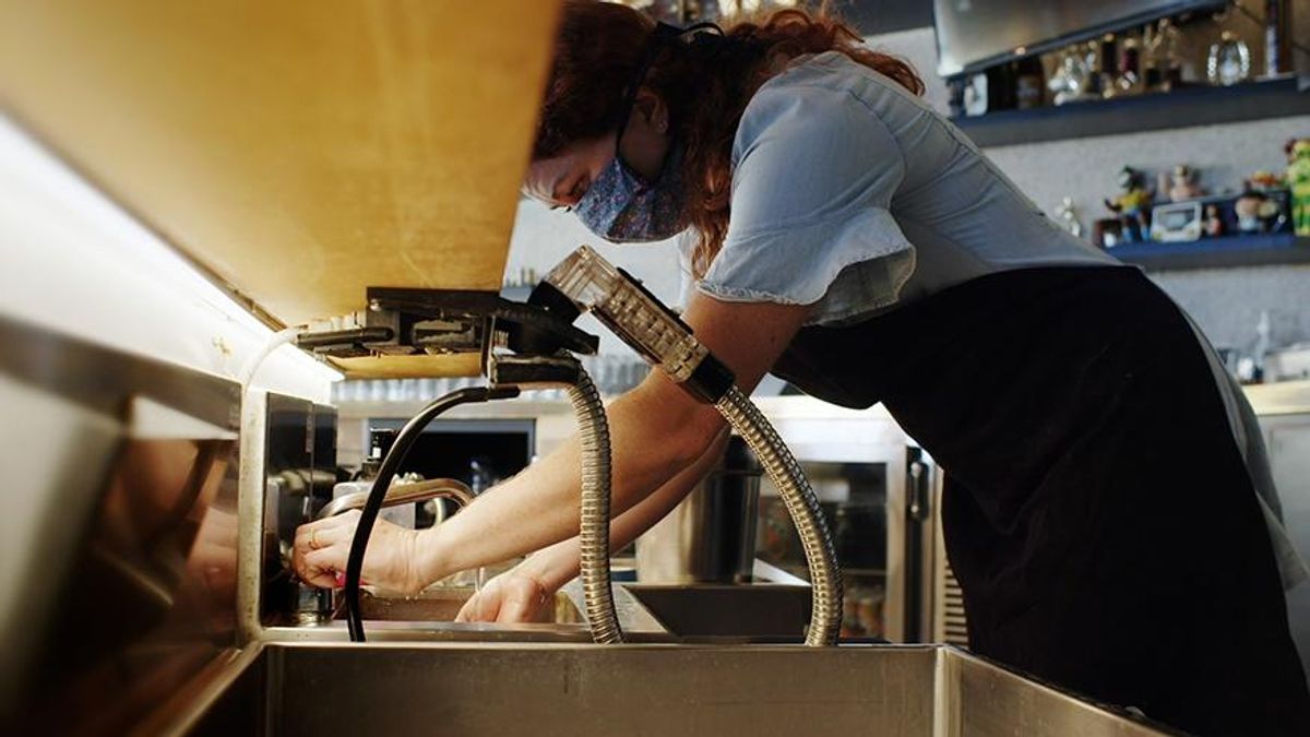 Woman business owner working at a sink