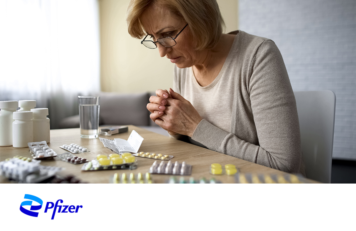 Woman staring at pills. 