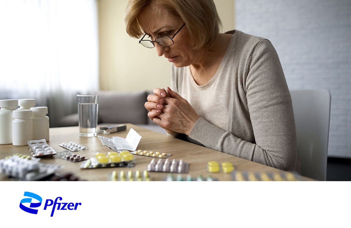 Woman staring at pills.