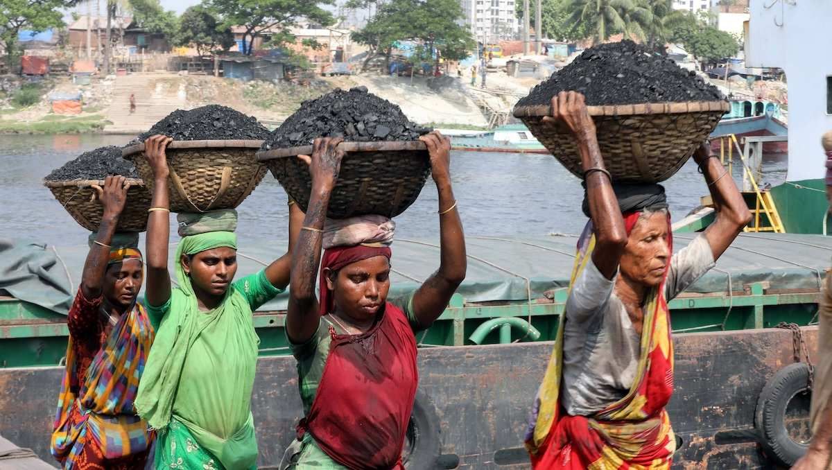 Workers are unloading coal from a cargo ship on the Turag River in Dhaka, Bangladesh, on May 06, 2024. 