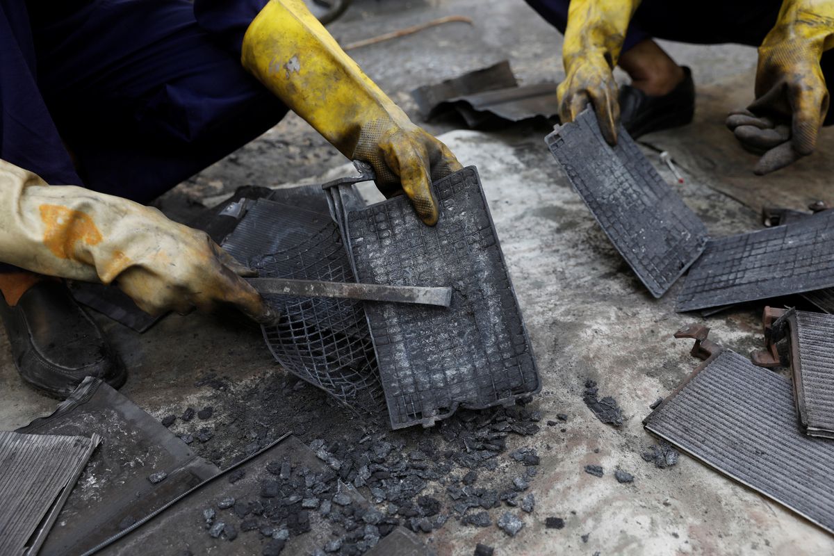 Workers dismantle batteries to obtain lead from them at ACE Green recycling Inc on the outskirts of New Delhi.