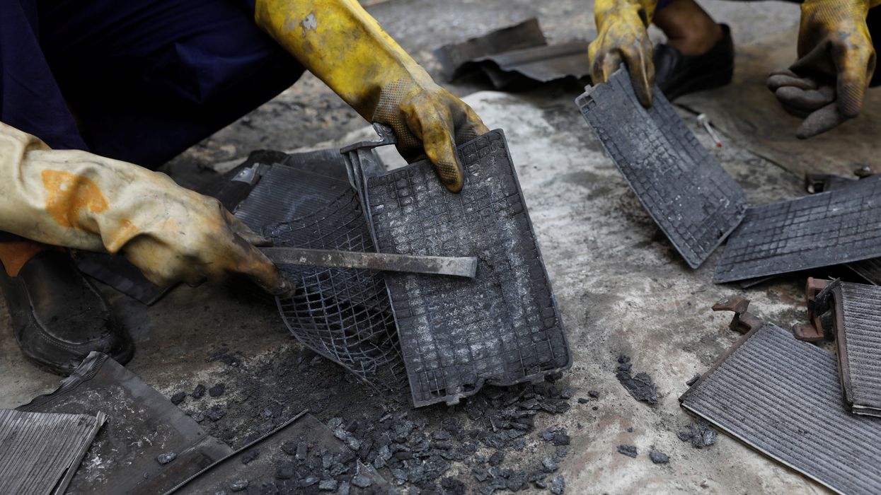 Workers dismantle batteries to obtain lead from them at ACE Green recycling Inc on the outskirts of New Delhi.