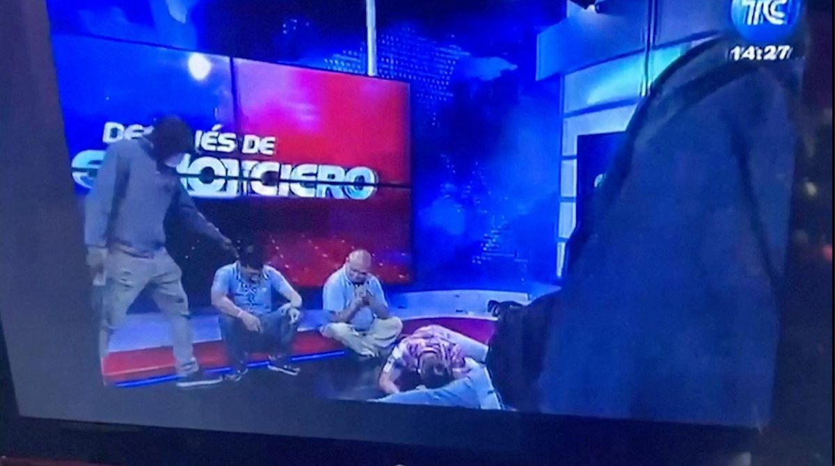 Workers lie on the floor as hooded and armed people take over a tv studio of Ecuador's TV station TC during a live broadcast, in this still image of a Reuters' recording of the affair of TC signal channel, in Guayaquil, Ecuador, January 9, 2024.